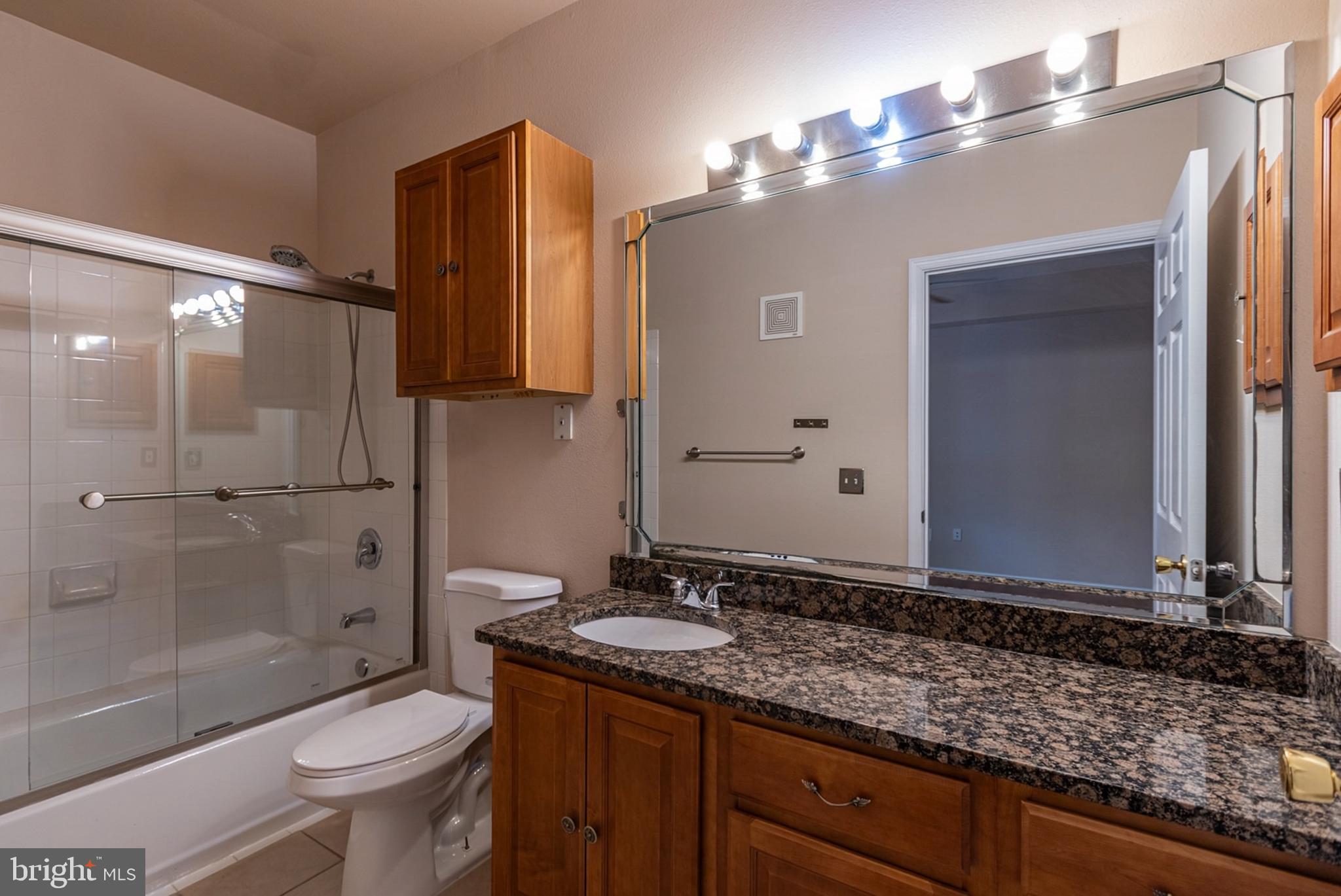 1600 Spring Gate Dr., Unit 2207 McLean, VA 22102 - Photo 18 of 32 a bathroom with a granite countertop sink toilet and shower