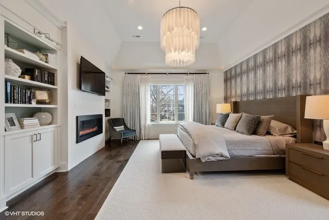 a spacious bedroom with a bed a fireplace and a large window