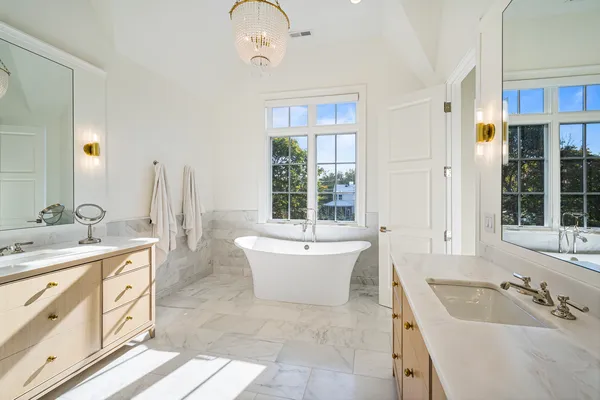 a spacious bathroom with a tub sink and mirror