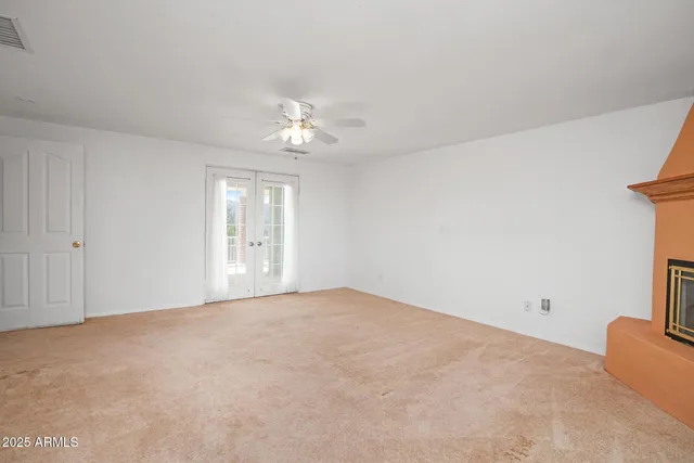 a view of an empty room with a window and a fireplace
