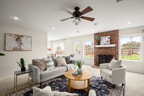 a living room with furniture a fireplace and a large window