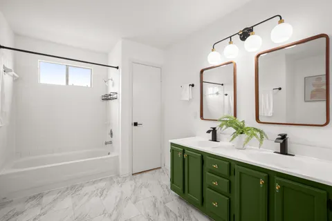 a bathroom with a double vanity sink mirror and shower