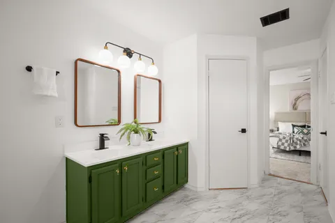 a bathroom with a double vanity sink mirror and shower