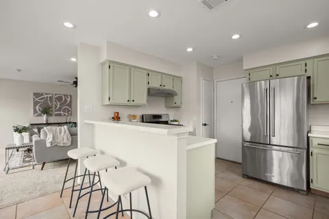 a kitchen with stainless steel appliances granite countertop a refrigerator and a stove top oven