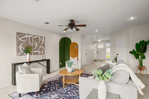 a living room with furniture a chandelier and a rug