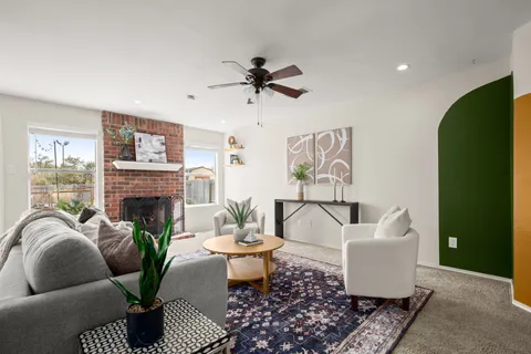 a living room with furniture a fireplace and a potted plant
