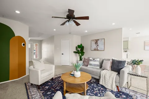 a living room with furniture and a potted plant
