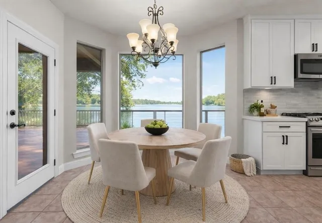 a view of a dining room with furniture a chandelier and window