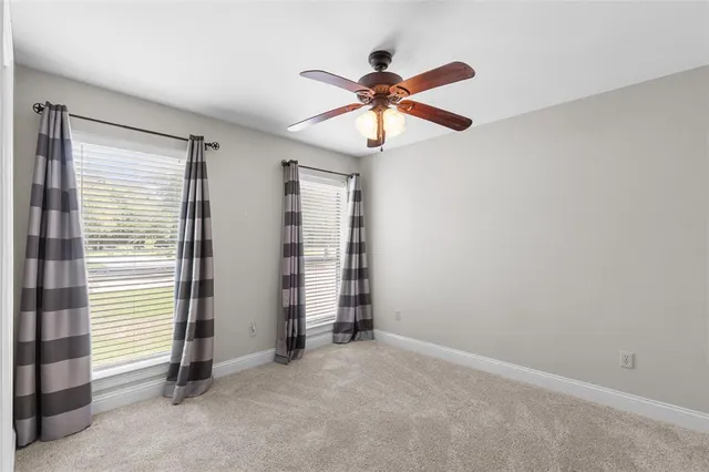 an empty room with closet and a ceiling fan