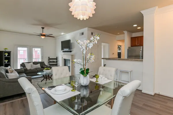 a view of a dining room with furniture a chandelier and wooden floor