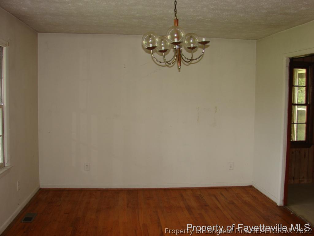 980 Carroll Store Road Autryville, NC 28318 - Photo 11 of 17 a view of empty room with window and chandelier