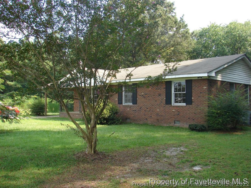 980 Carroll Store Road Autryville, NC 28318 - Photo 3 of 17 a view of a yard in front of a house with plants and large tree