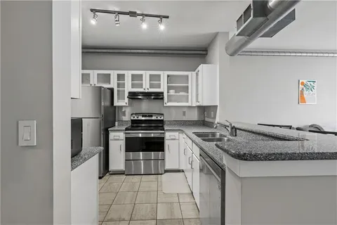 a kitchen with stainless steel appliances granite countertop a stove sink and cabinets
