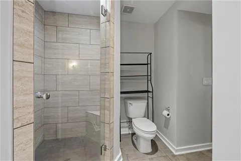 a bathroom with a toilet and a shower