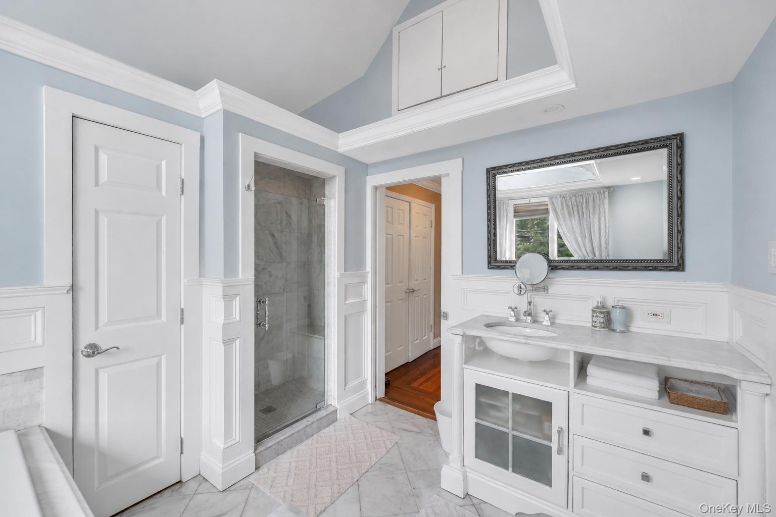 19 Joan Road Bay Shore, NY 11706 - Photo 28 of 50 Bathroom featuring a glass-enclosed shower, white vanity with an undermount sink, marble-finish countertop, and decorative mirror