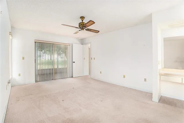 a view of a room with a ceiling fan and a window