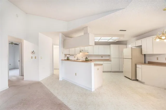 a kitchen with white cabinets and white appliances