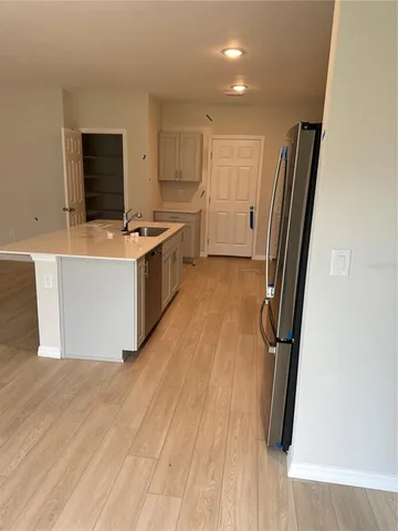 a large kitchen with stainless steel appliances a refrigerator and a stove top oven