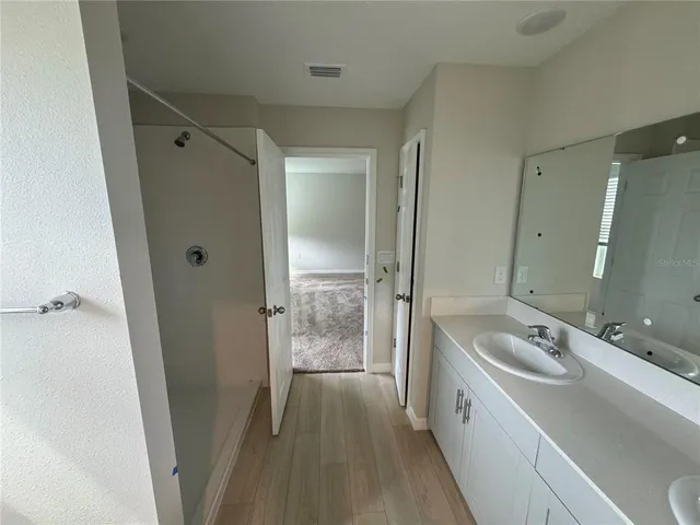 a spacious bathroom with a tub sink a mirror and a shower