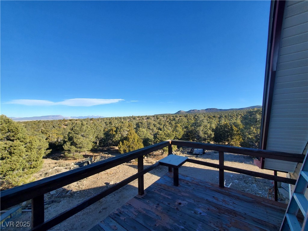 1281 Meadow Lane Pioche, NV 89043 - Photo 9 of 34 Wooden terrace featuring a mountain view and a view of trees