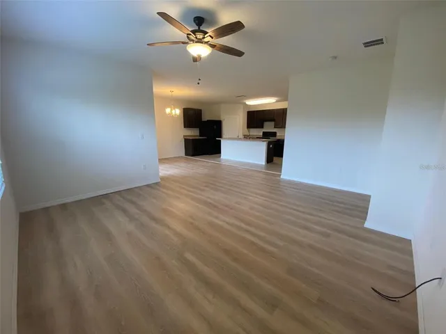 a view of kitchen with refrigerator stove and cabinets