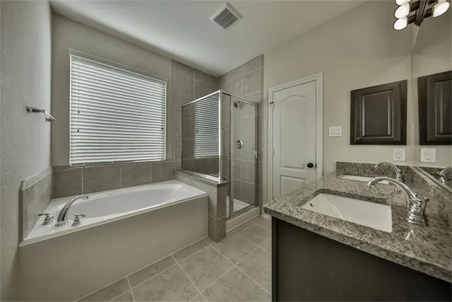a bathroom with a granite countertop sink mirror bathtub and shower