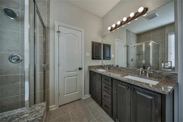 a bathroom with a granite countertop sink shower and a mirror