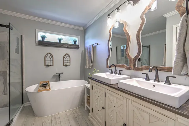 a bathroom with a double vanity sink mirror and bathtub