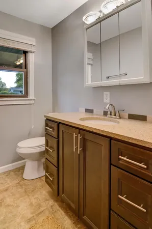a bathroom with a sink a toilet and a window