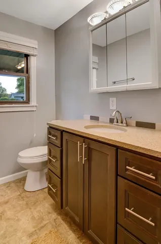 a bathroom with a sink a toilet and a window