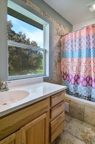 a view of bathroom with a sink and mirror