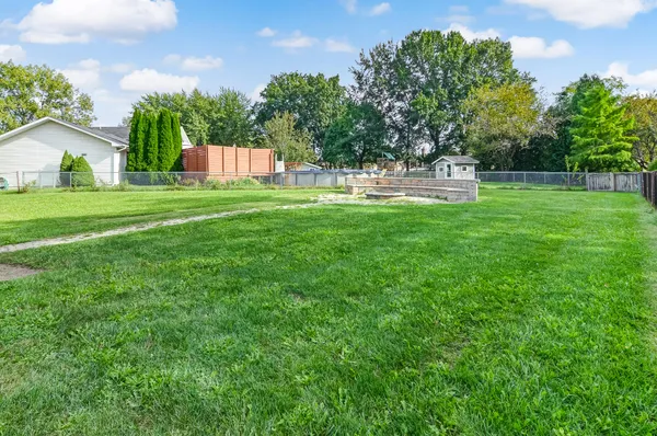a view of house with backyard and a garden