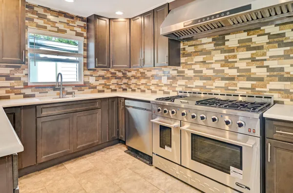 a kitchen with a stove sink and cabinets