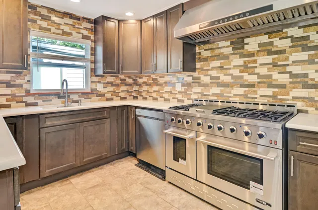 a kitchen with a stove sink and cabinets