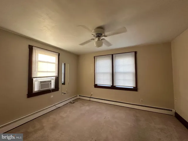 an empty room with a window and a ceiling fan