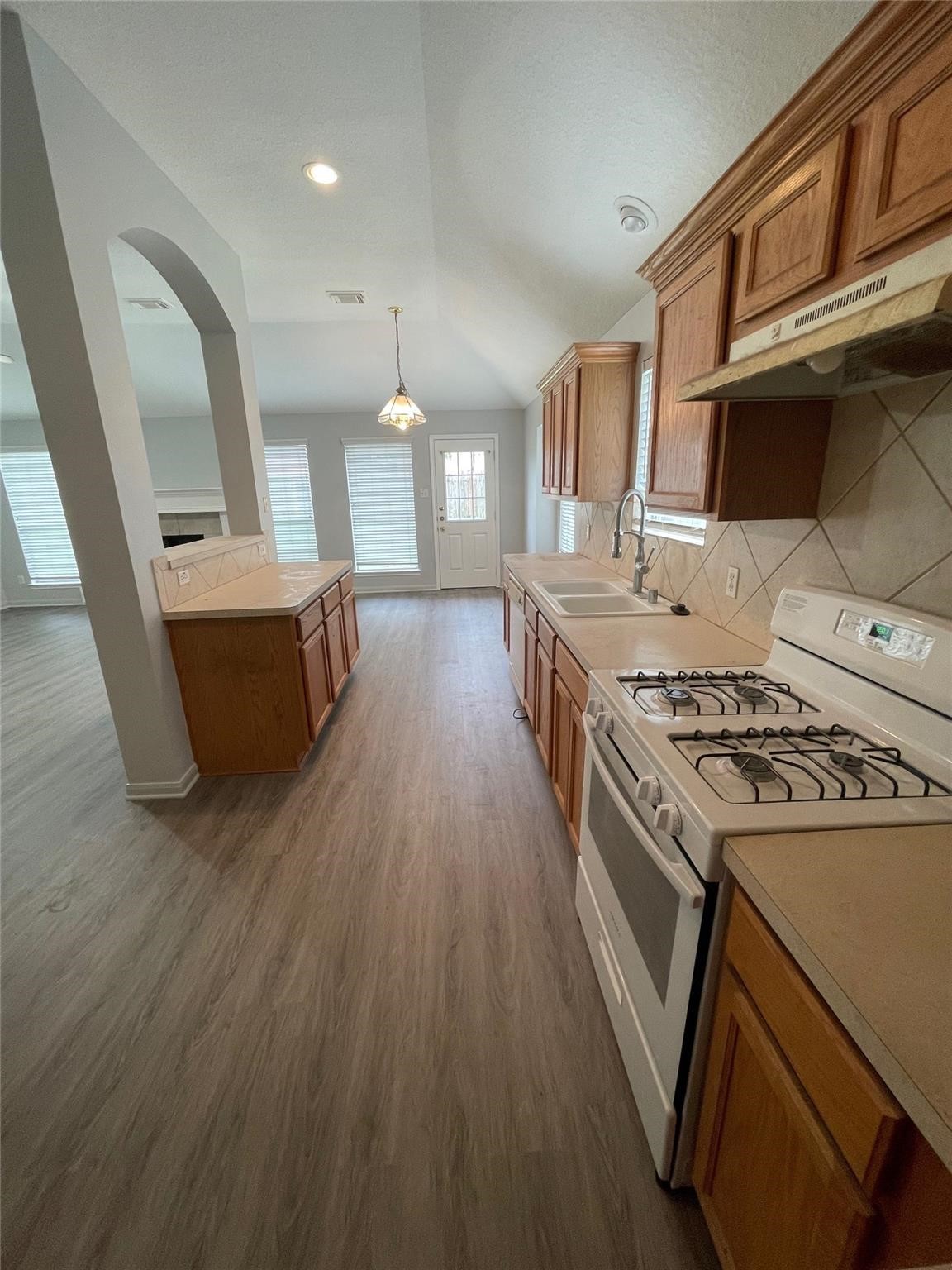 3310 North Mason Road Katy, TX 77449 - Photo 6 of 14 a kitchen with a stove a sink and a wooden floors