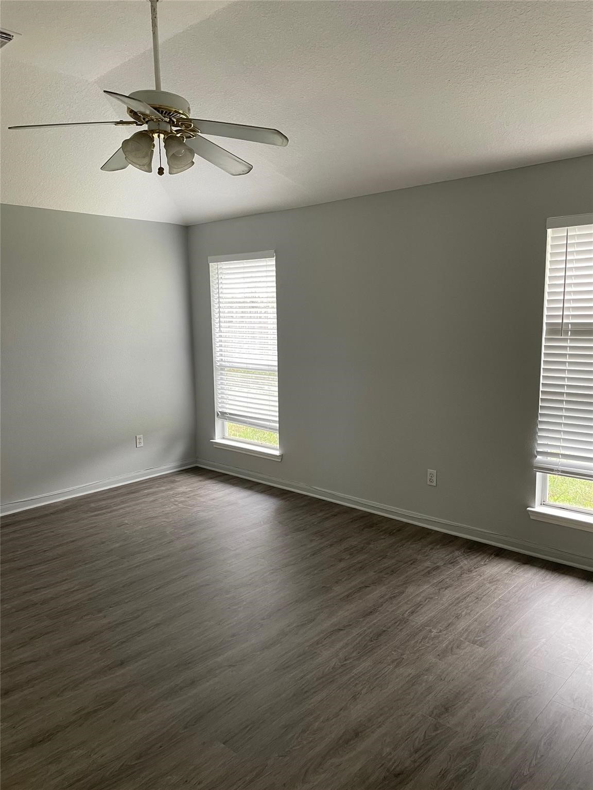 3310 North Mason Road Katy, TX 77449 - Photo 10 of 14 an empty room with wooden floor fan and windows