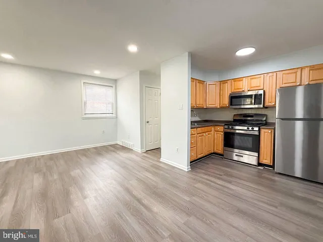 a kitchen with wooden floors and stainless steel appliances