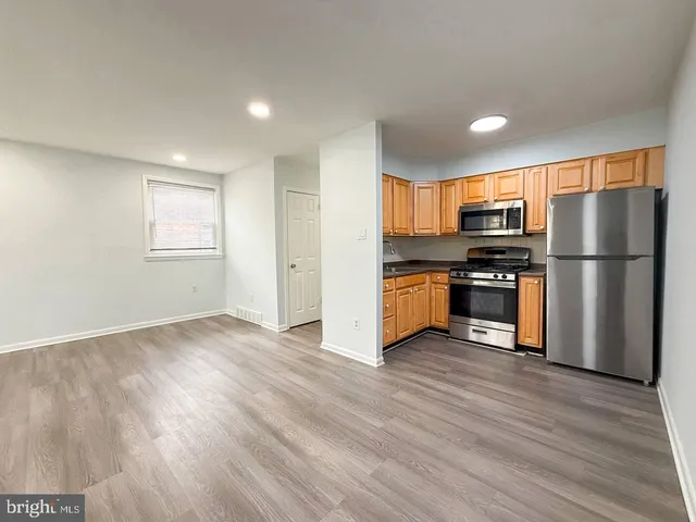a kitchen with wooden floors and stainless steel appliances