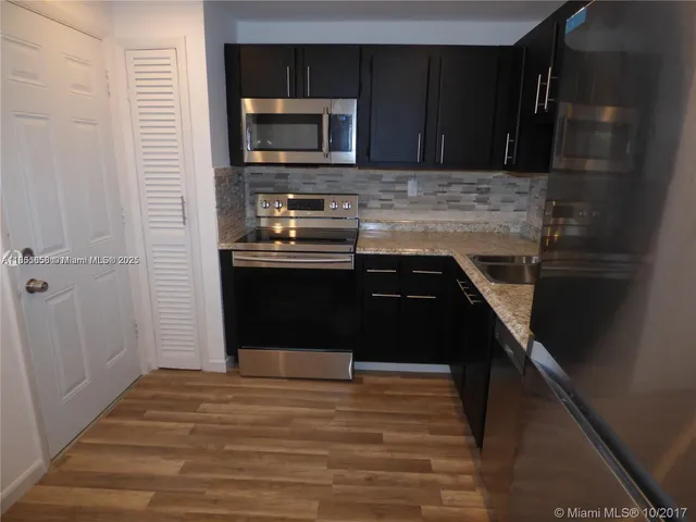 a kitchen with a sink and stainless steel appliances