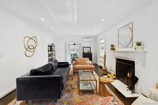 a living room with furniture a fireplace and wooden floor