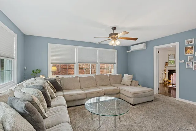 a living room with furniture ceiling fan and a window