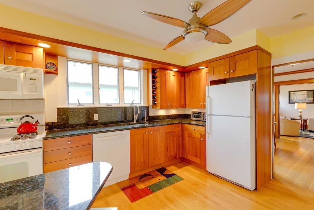 4 Hilltop Road Watertown, MA 02472 - Photo 14 of 27 a kitchen with granite countertop a refrigerator a sink dishwasher stove and refrigerator with wooden floor