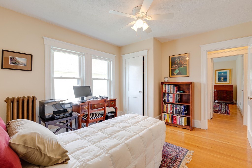 4 Hilltop Road Watertown, MA 02472 - Photo 19 of 27 a bedroom with a bed and a book shelf