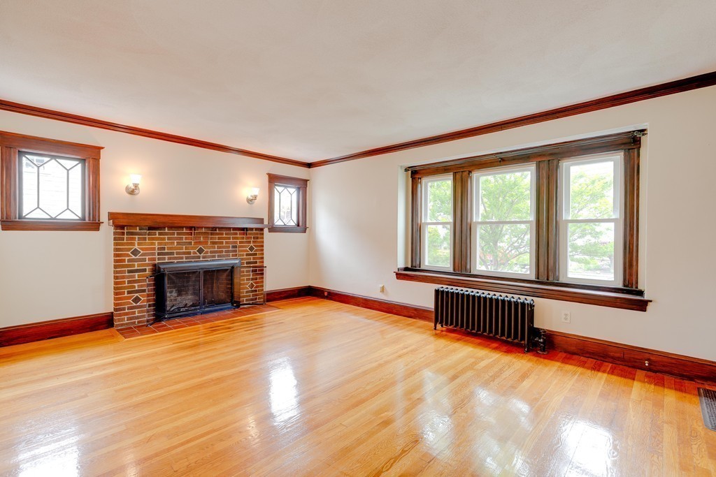 4 Hilltop Road Watertown, MA 02472 - Photo 6 of 27 a view of an empty room with a fireplace and a window