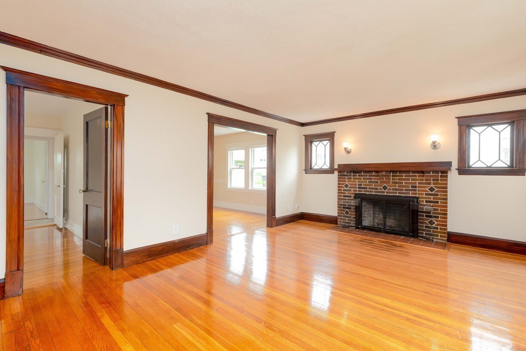 4 Hilltop Road Watertown, MA 02472 - Photo 7 of 27 a view of a livingroom with wooden floor and a fireplace