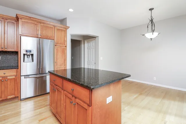 a kitchen with stainless steel appliances granite countertop a refrigerator a sink and a stove