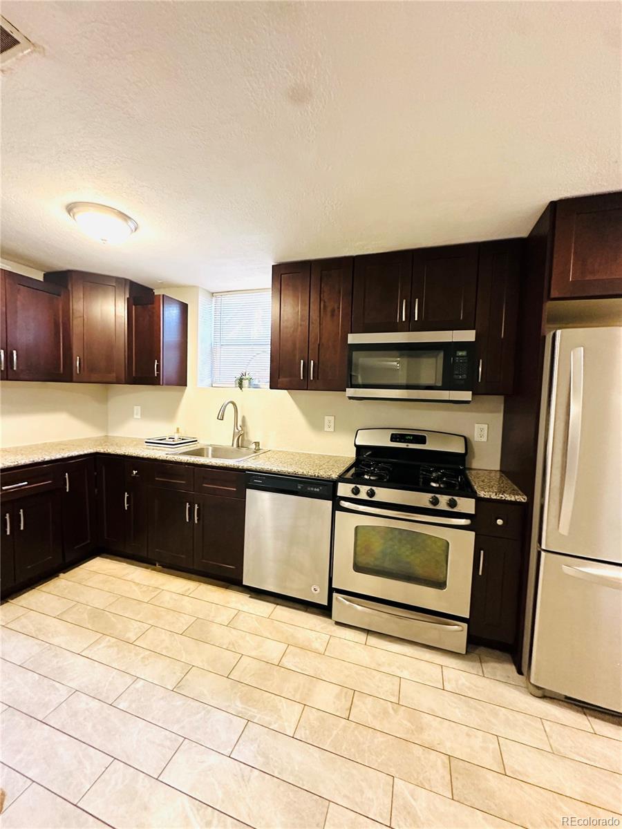 1400 South Clermont Street, Unit 8 Denver, CO 80222 - Photo 3 of 11 a kitchen with stainless steel appliances granite countertop a sink stove and refrigerator