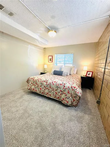 a bedroom with a bed and painting on the wall