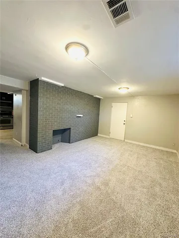 an empty room with kitchen and glass door